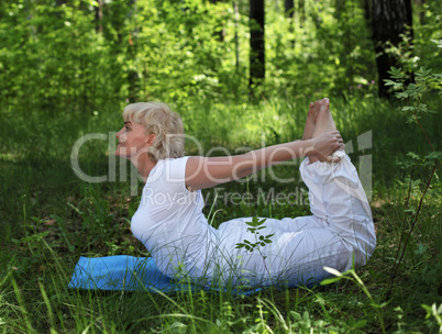 An elderly woman practices yoga