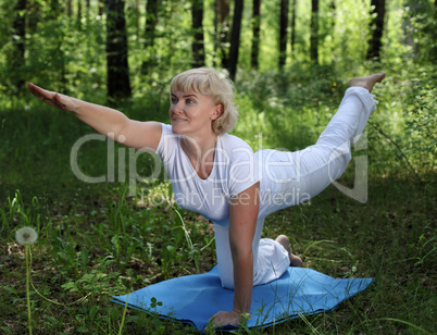 An elderly woman practices yoga