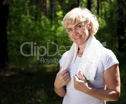 Portrait of an elderly woman in sportswear with a towel