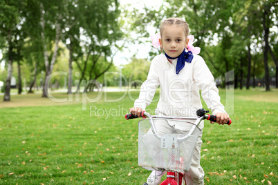 Girl on a bicycle in the green park