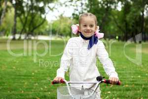 Girl on a bicycle in the green park