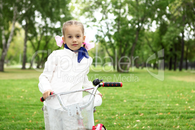 Girl on a bicycle in the green park