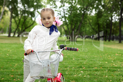 Girl on a bicycle in the green park