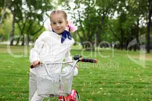 Girl on a bicycle in the green park