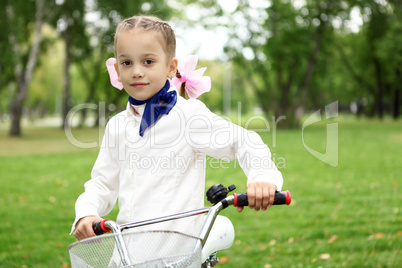 Girl on a bicycle in the green park