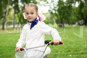 Girl on a bicycle in the green park