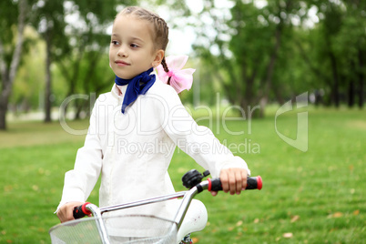 Girl on a bicycle in the green park