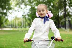 Girl on a bicycle in the green park