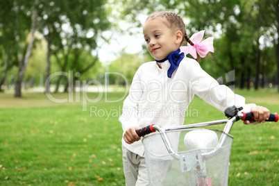 Girl on a bicycle in the green park