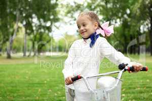 Girl on a bicycle in the green park