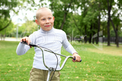Boy on a bicycle in the green park