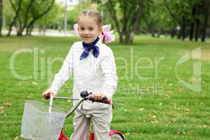 Girl on a bicycle in the green park