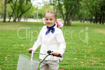 Girl on a bicycle in the green park