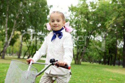 Girl on a bicycle in the green park