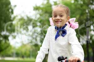 Girl on a bicycle in the green park