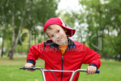 Boy on a bicycle in the green park