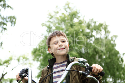 Boy on a bicycle in the green park