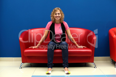 Young woman sitting on red sofa