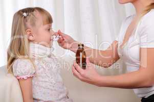 Little girl drinking cough syrup