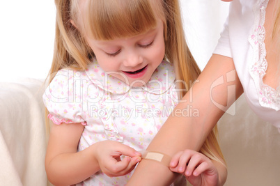 little girl puts a plaster