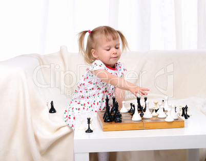 Little girl playing chess