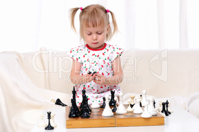 Little girl playing chess