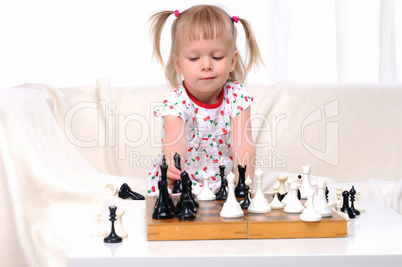 Little girl playing chess