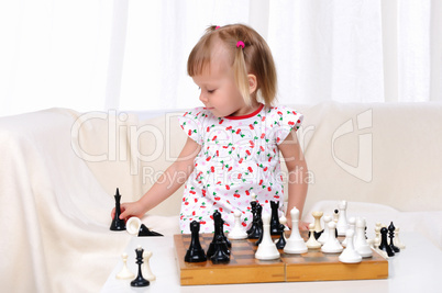 Little girl playing chess