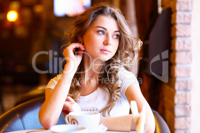 Young pretty woman sitting in restaurant