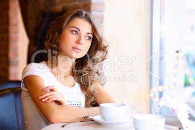 Young pretty woman sitting in restaurant