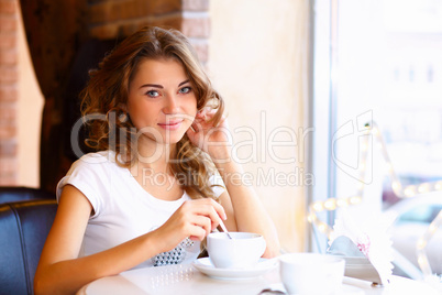 Young pretty woman sitting in restaurant