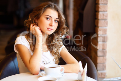 Young pretty woman sitting in restaurant