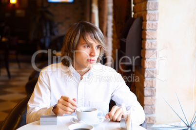 Young handsome man sitting in restaurant