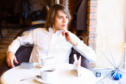 Young handsome man sitting in restaurant
