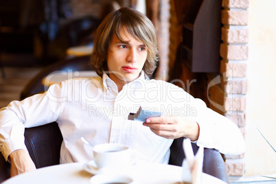 Young handsome man sitting in restaurant