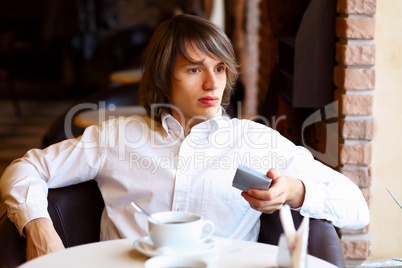 Young handsome man sitting in restaurant