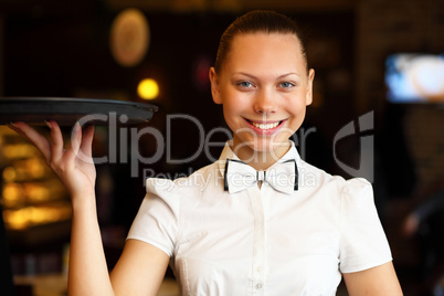 Portrait of young waitress holding a tray