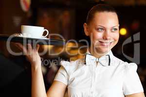 Portrait of young waitress holding a tray
