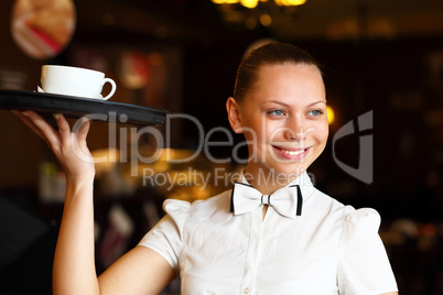 Portrait of young waitress holding a tray