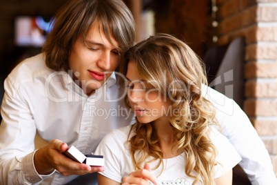 Young couple with engagement ring in a restaurant