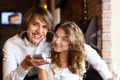 Young couple with engagement ring in a restaurant