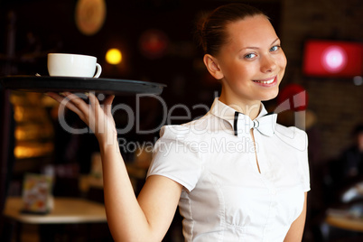 Portrait of young waitress holding a tray