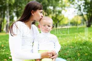 Young mother with her son in summer park