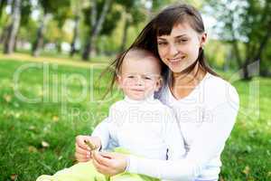 Young mother with her son in summer park