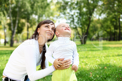 Young mother with her son in summer park