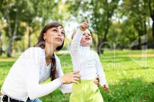 Young mother with her son in summer park