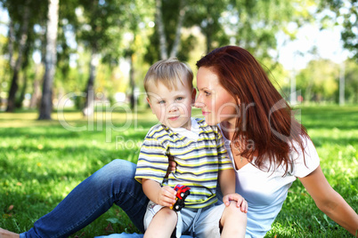 Young mother with her son in summer park