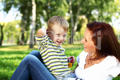 Young mother with her son in summer park