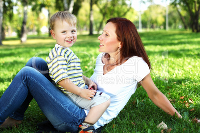 Young mother with her son in summer park