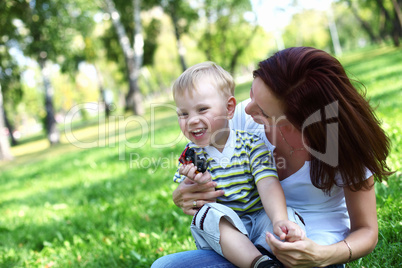 Young mother with her son in summer park